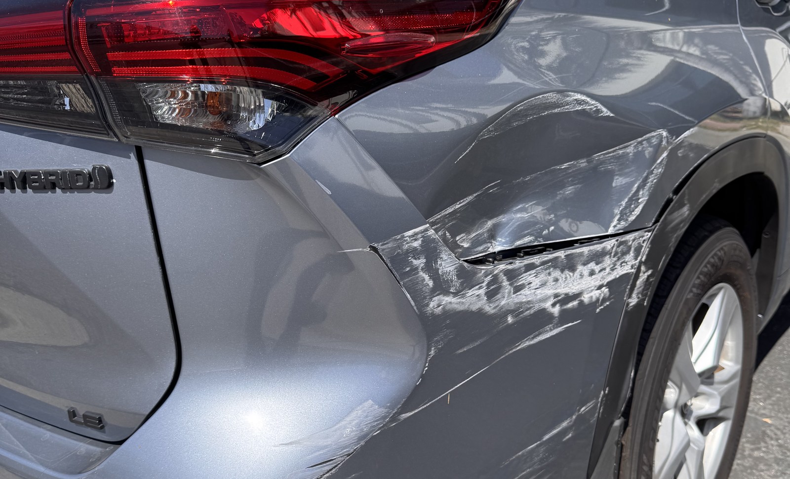 Wide view of rear-quarter collision damage before repair assessment