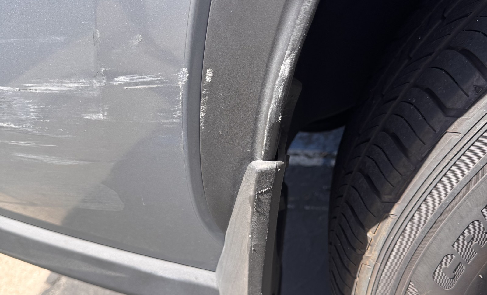 Lower bumper and wheel-area detail after visible impact damage